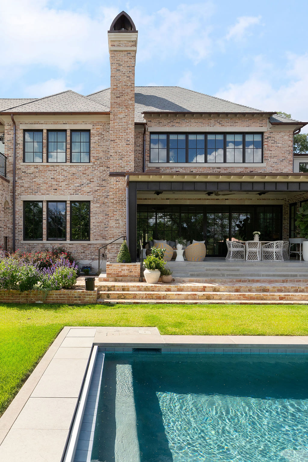 Brick two-story home with a natural slate roof and pool terrace