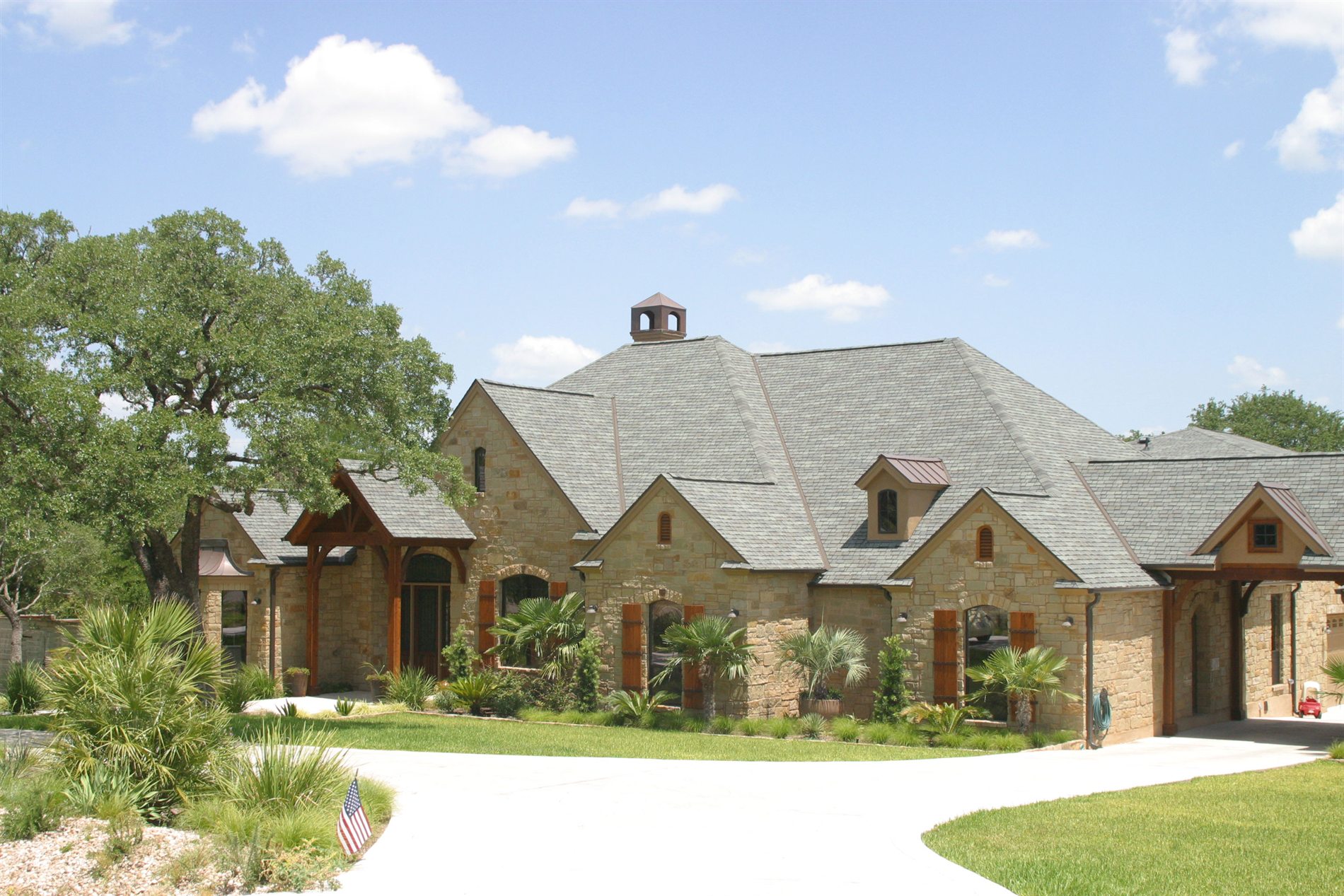 Stone home with a grey slate roof and copper-capped cupola