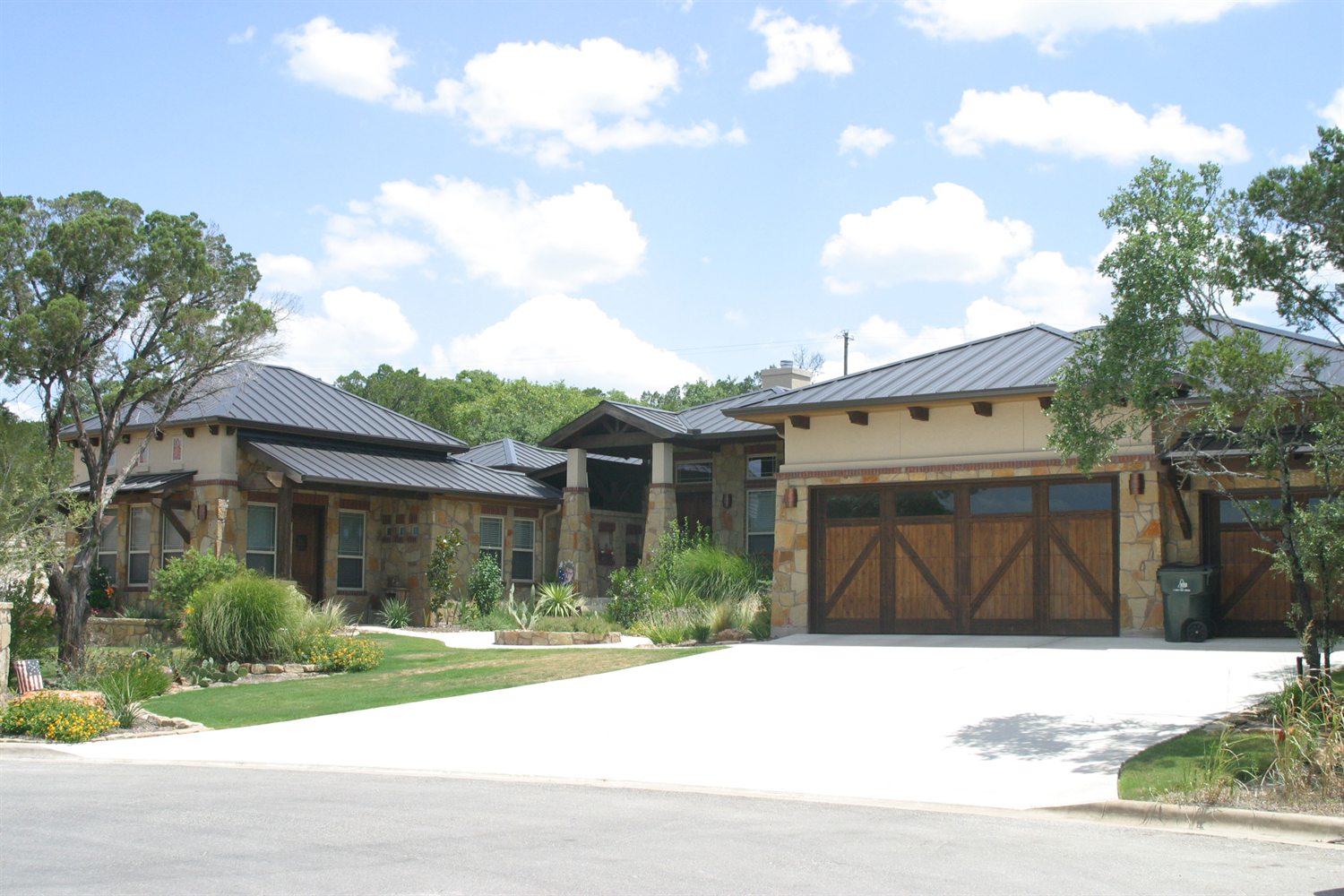 Contemporary Hill Country home with a dark standing-seam metal roof