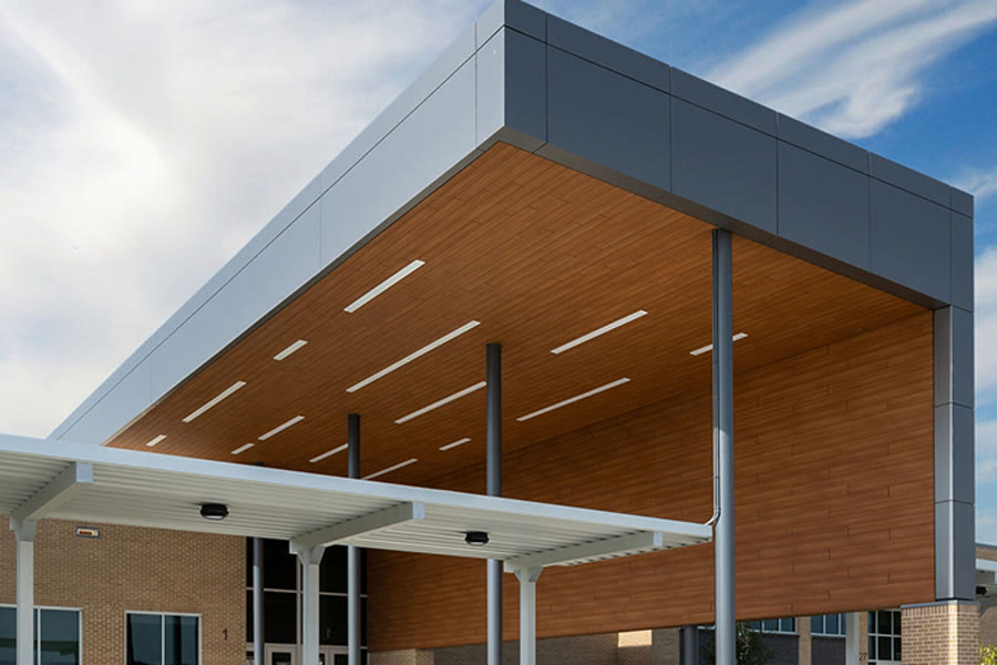 Wood-grain and charcoal aluminum composite material panel canopy at a school entry