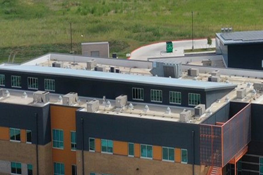 White single-ply membrane roof with HVAC curbs on a school building