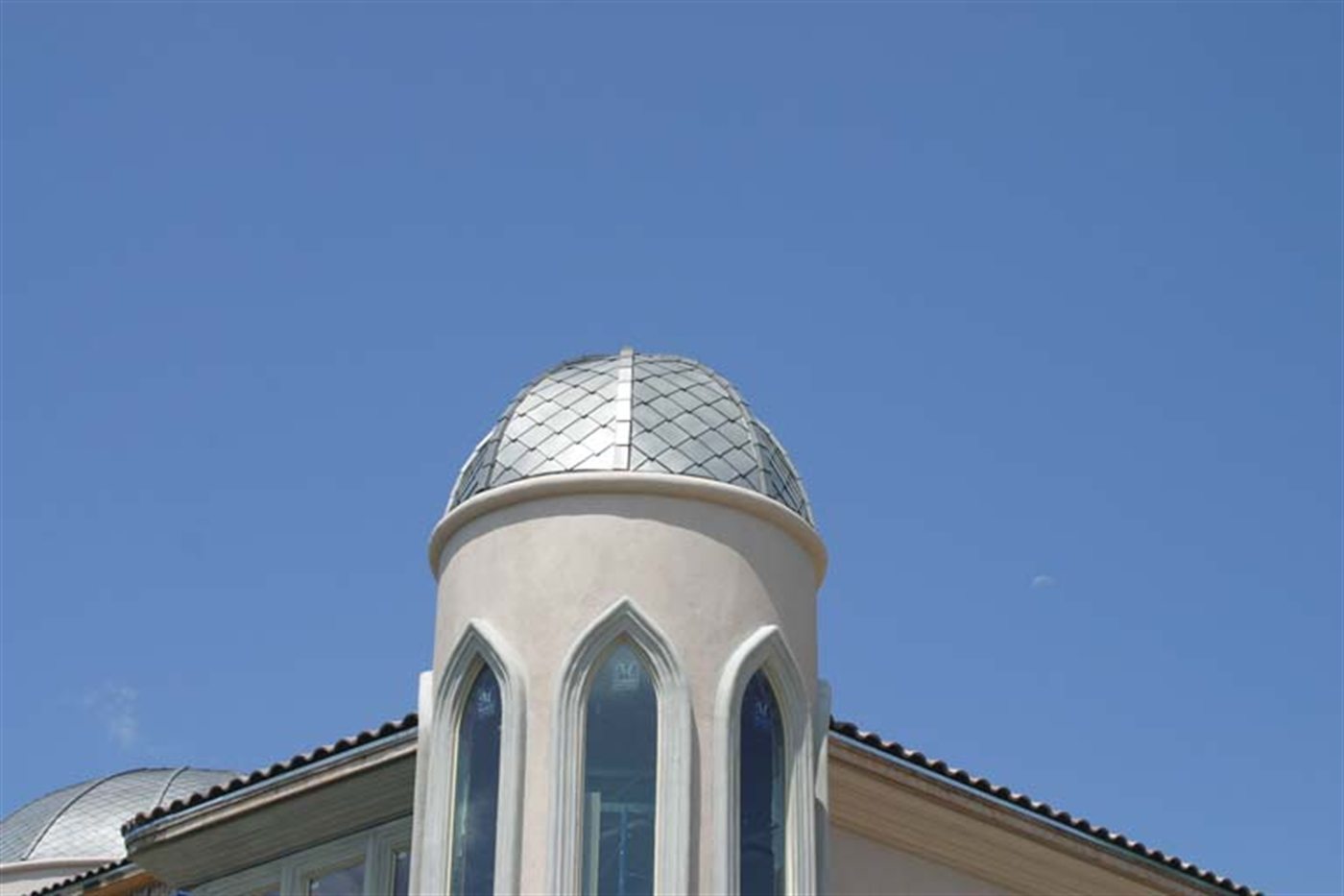 Stucco turret capped with a diamond-pattern metal dome